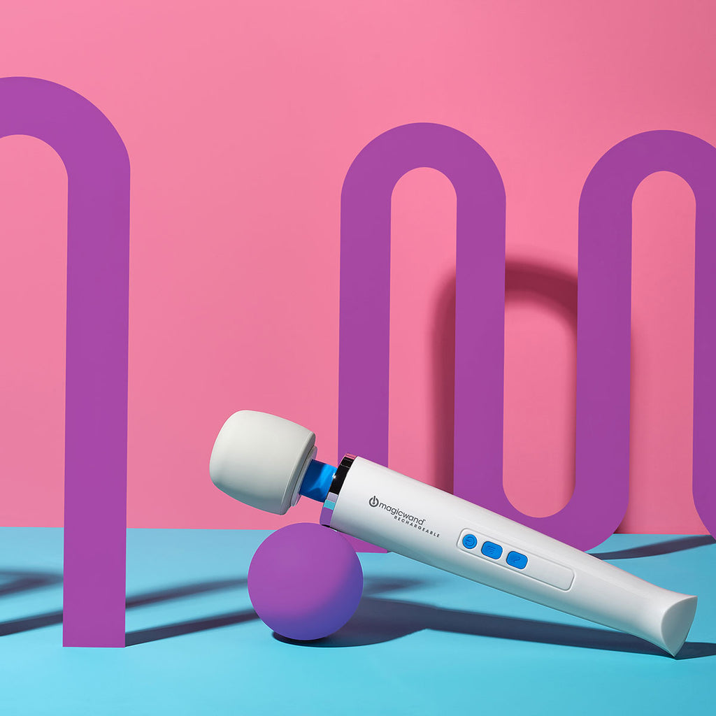 a Magic Wand vibrator its propped up on a purple sphere. against a pink and purple background. 